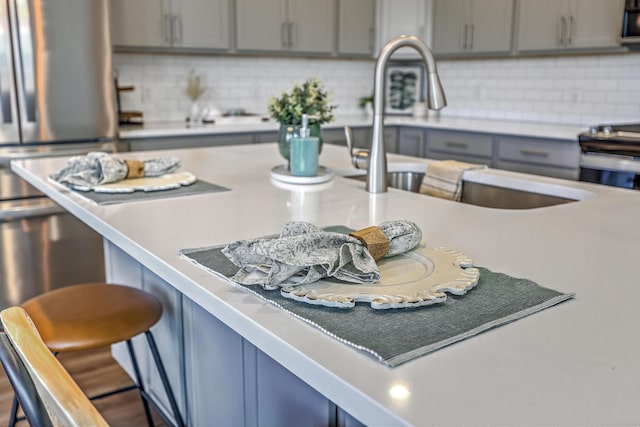 175 Darby Meadow Ln, Ridgeville, SC 29472 - kitchen featuring gray cabinets, a breakfast bar area, decorative backsplash, and light countertops