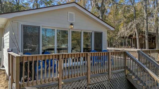 back of property with a sunroom and a deck