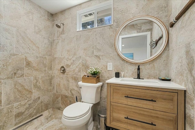 bathroom with vanity, toilet, and a tile shower