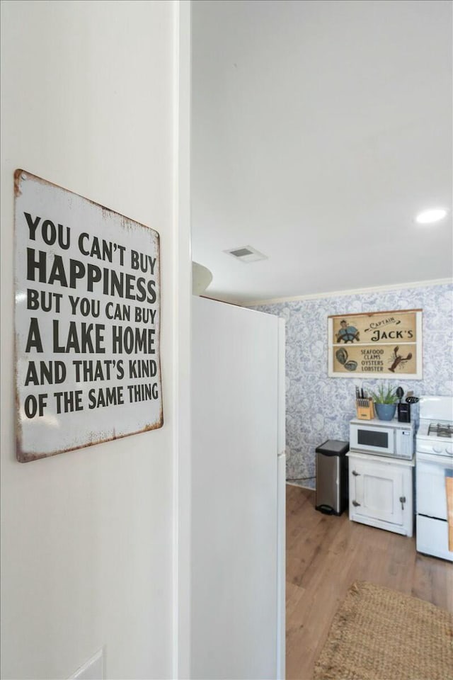 interior space featuring white appliances and hardwood / wood-style floors