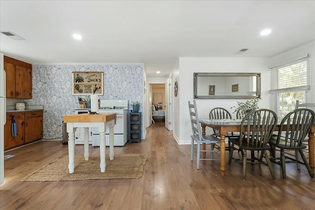 dining area with ornamental molding and hardwood / wood-style floors