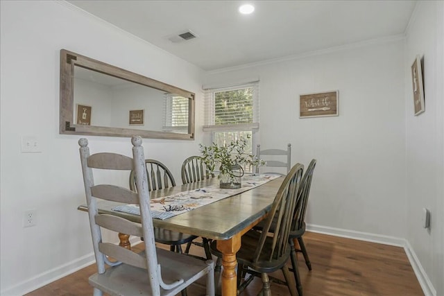 dining space with ornamental molding and dark wood-type flooring