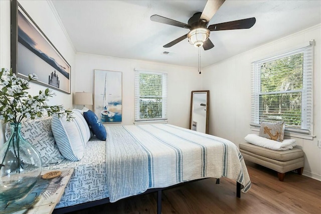 bedroom with hardwood / wood-style flooring, ornamental molding, and ceiling fan