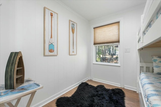 bedroom with wood-type flooring and ornamental molding