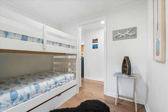 bedroom featuring crown molding and light hardwood / wood-style floors