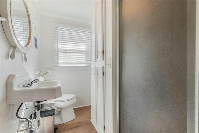 bathroom with ornamental molding, sink, hardwood / wood-style floors, and toilet