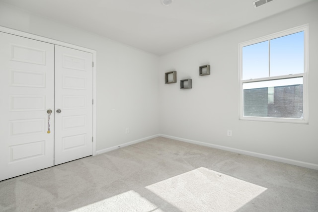 unfurnished room featuring light carpet