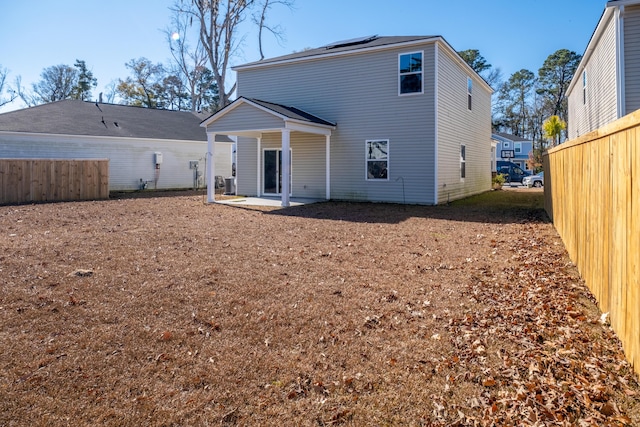 back of house with solar panels and a patio