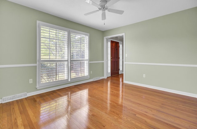 unfurnished room featuring visible vents, baseboards, ceiling fan, and wood finished floors