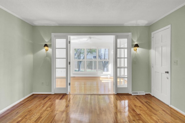interior space featuring wood finished floors, baseboards, a ceiling fan, and visible vents