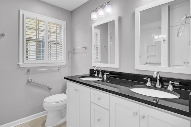full bath featuring walk in shower, double vanity, a sink, and toilet
