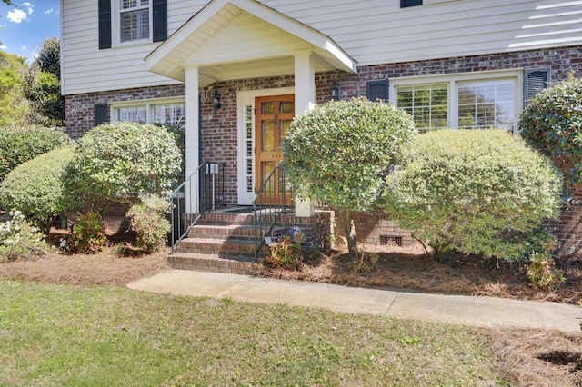doorway to property featuring brick siding