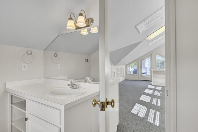 bathroom with vanity, visible vents, and vaulted ceiling