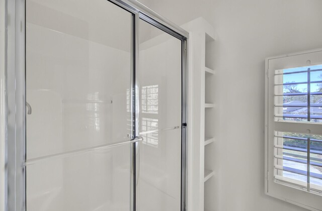 full bathroom with built in features and a stall shower