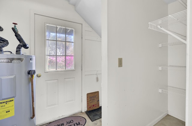 doorway to outside featuring lofted ceiling and water heater