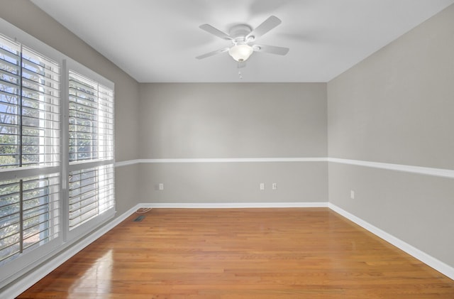 unfurnished room featuring baseboards, a ceiling fan, and wood finished floors