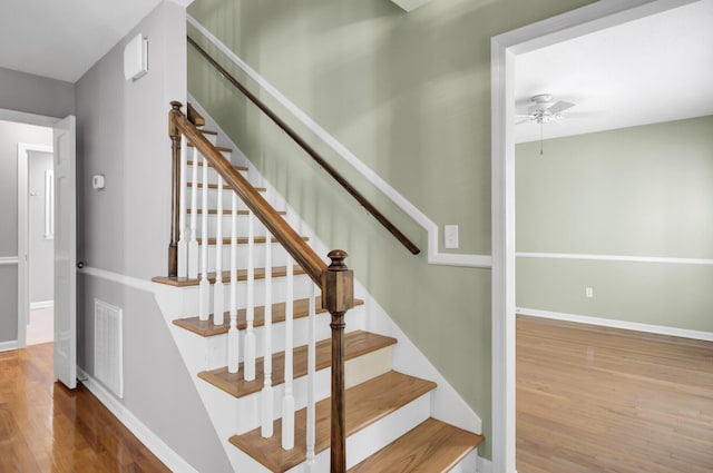 stairs featuring visible vents, ceiling fan, baseboards, and wood finished floors