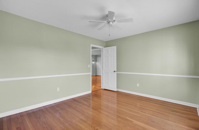 interior space featuring ceiling fan, baseboards, and wood finished floors