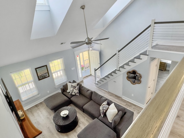 1410 Diamond Blvd, Mount Pleasant, SC 29466 - living room with light wood-style flooring, a skylight, high vaulted ceiling, stairway, and a ceiling fan