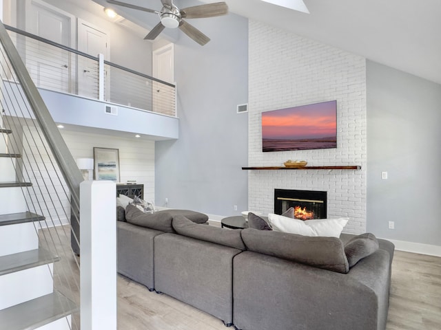 1410 Diamond Blvd, Mount Pleasant, SC 29466 - living area featuring a brick fireplace, wood finished floors, high vaulted ceiling, stairs, and a ceiling fan