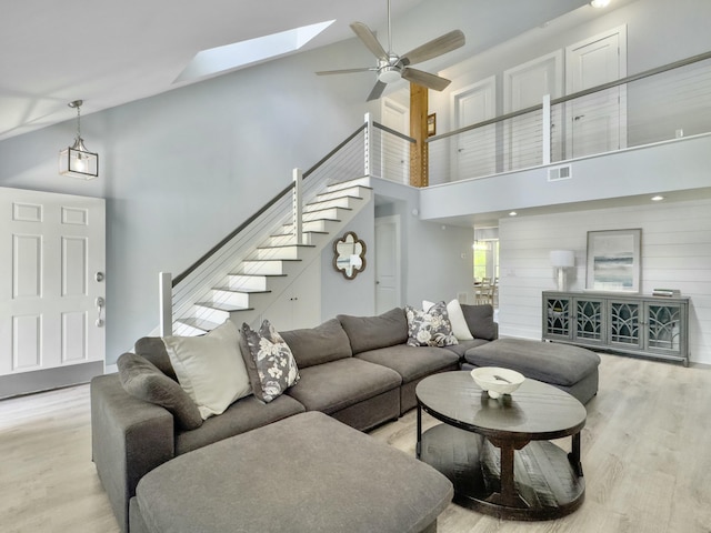 1410 Diamond Blvd, Mount Pleasant, SC 29466 - living room featuring stairway, light wood-style flooring, a skylight, high vaulted ceiling, and ceiling fan