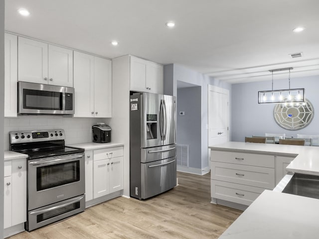 1410 Diamond Blvd, Mount Pleasant, SC 29466 - kitchen featuring stainless steel appliances, white cabinets, backsplash, light countertops, and recessed lighting