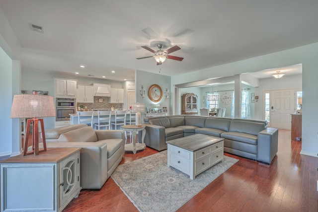 living room with dark wood-type flooring and ceiling fan