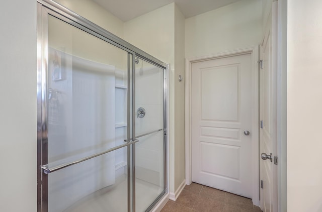 bathroom with tile patterned flooring and a shower with shower door