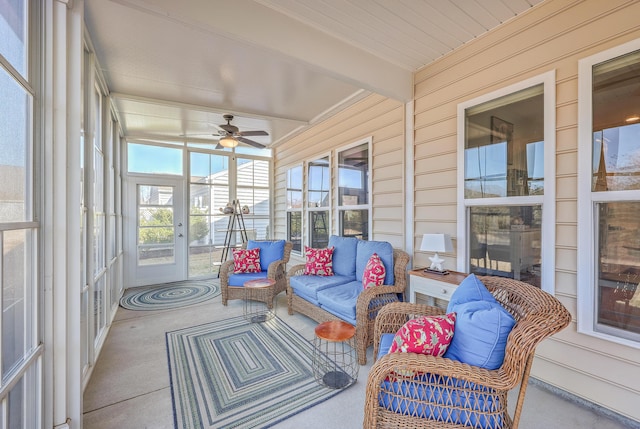 sunroom featuring beamed ceiling and ceiling fan