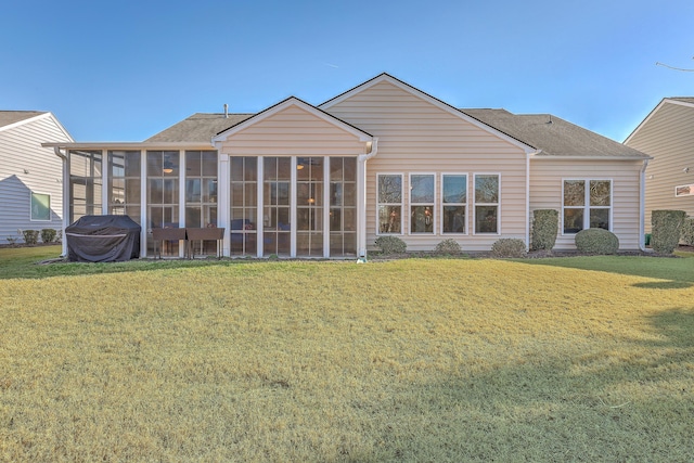 rear view of property with a yard and a sunroom