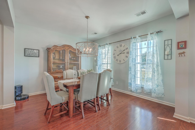 dining area featuring dark wood-type flooring and a chandelier