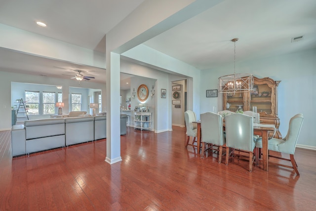 dining space featuring wood-type flooring and ceiling fan with notable chandelier