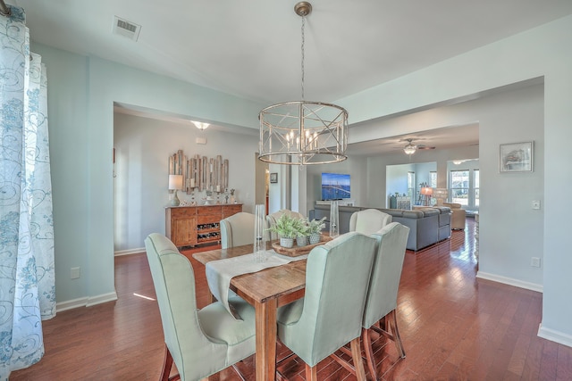 dining area with dark hardwood / wood-style floors and a notable chandelier