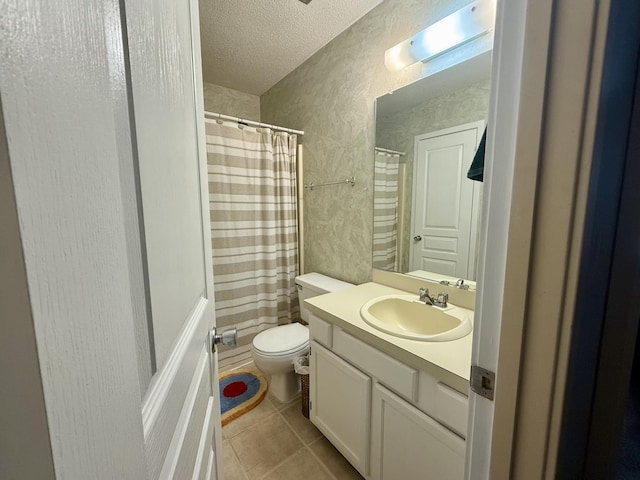 bathroom with vanity, toilet, a textured ceiling, tile patterned floors, and a shower with curtain