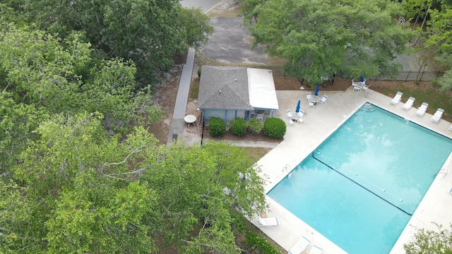 community pool with a patio area and fence