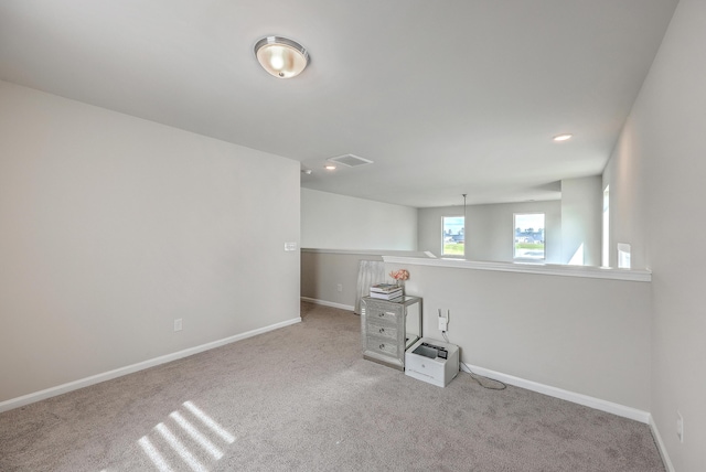 carpeted spare room featuring recessed lighting, baseboards, and visible vents