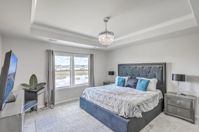 bedroom with visible vents, carpet flooring, and a raised ceiling