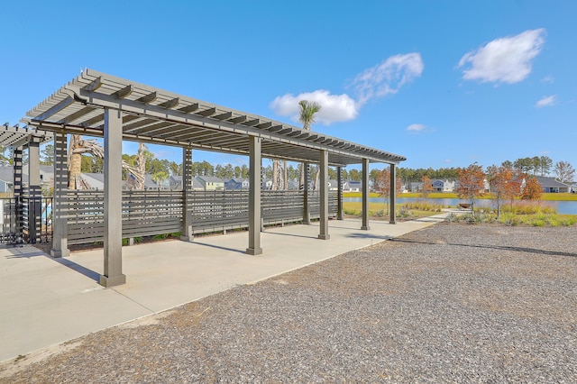 view of patio / terrace with fence, a pergola, and a water view