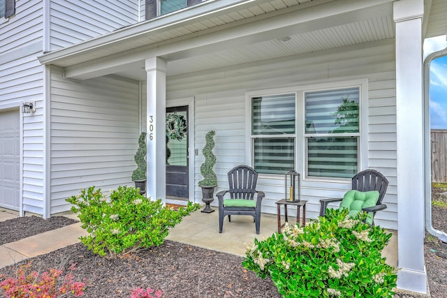 view of exterior entry featuring a porch and a garage