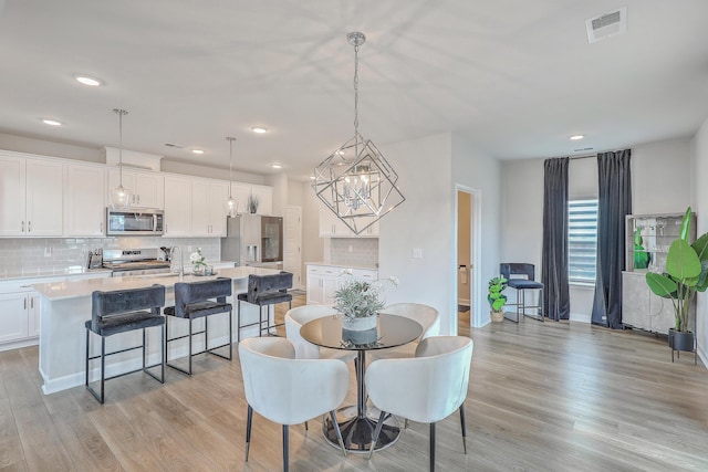 dining room featuring a chandelier, visible vents, recessed lighting, and light wood finished floors