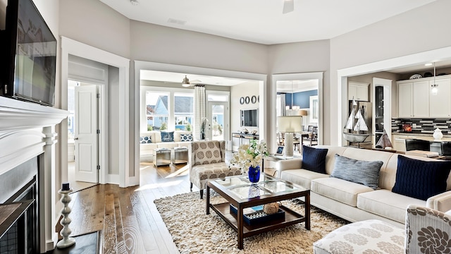 living room with wood-type flooring and ceiling fan