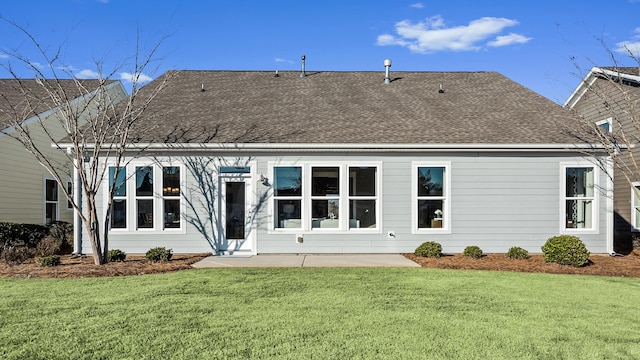 rear view of house with a lawn and a patio