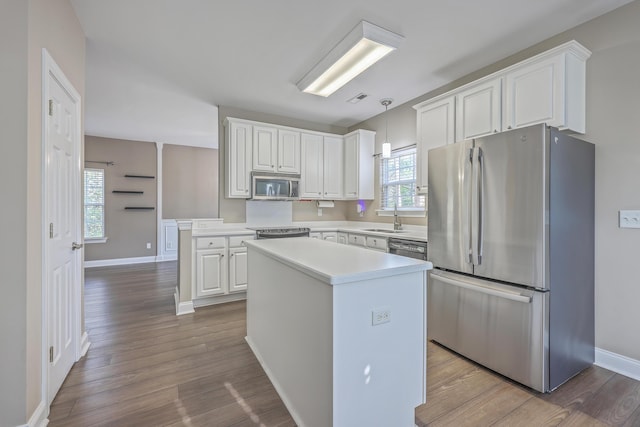 401 Waring St, Summerville, SC 29483 - kitchen with stainless steel appliances, a kitchen island, wood finished floors, and white cabinets