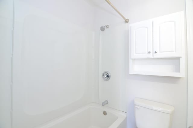 bathroom with bathing tub / shower combination and toilet