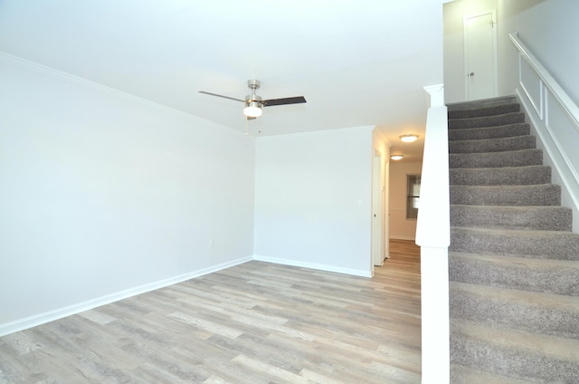 interior space featuring light wood-style flooring, stairway, baseboards, and ornamental molding