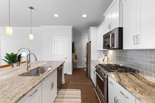 kitchen with decorative light fixtures, sink, white cabinetry, light stone countertops, and appliances with stainless steel finishes