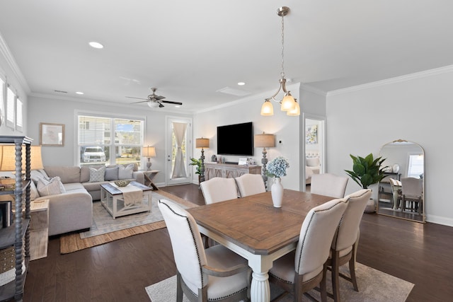 dining area featuring dark hardwood / wood-style flooring, ceiling fan with notable chandelier, and crown molding