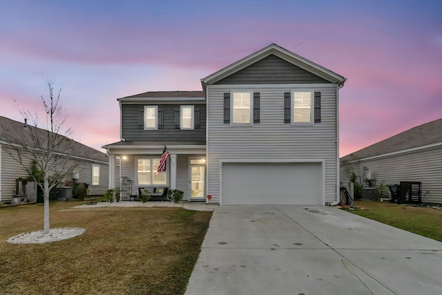 traditional-style home featuring concrete driveway, an attached garage, covered porch, cooling unit, and a yard