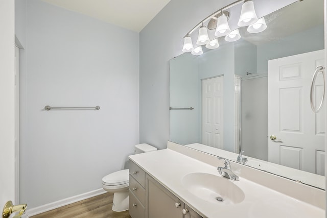 bathroom featuring walk in shower, hardwood / wood-style flooring, vanity, and toilet