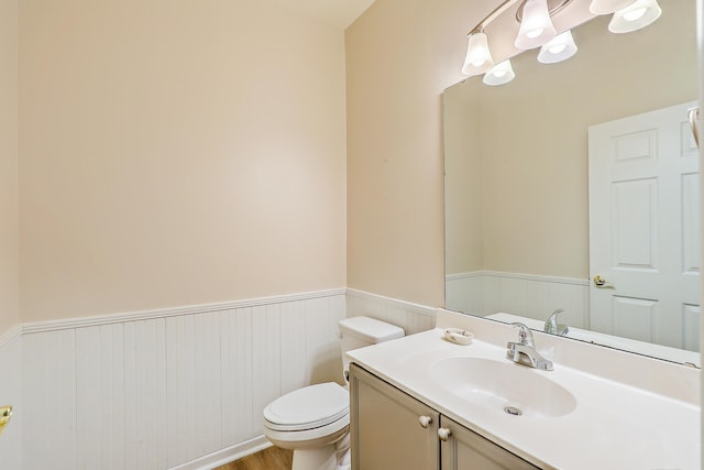 bathroom featuring wood-type flooring, vanity, and toilet